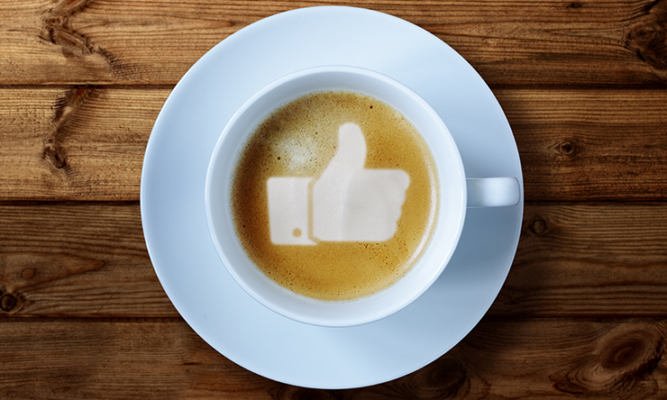A cup of coffee with the iconic thumbs up icon from facebook
