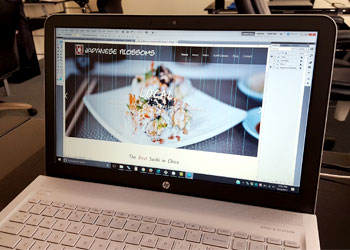 Photo depicts a a custom web design being created on a laptop.