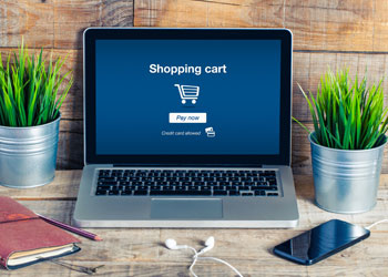 A photo of a laptop with a shopping cart on it